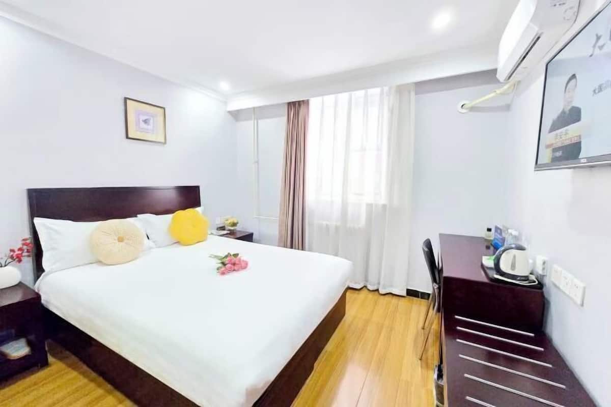 Une chambre d’hôtel avec un grand lit, un bureau et une chaise.