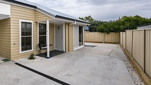 A single-story house with a covered patio area, a fenced backyard, and a visible number '2' on the door. - Wolaroi Villa 2, with Netflix and Disney Plus - In a Quiet Street (Orange)