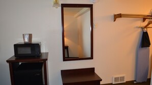 A compact room with a microwave on a small table, a bench, a mirror, and a clothes drying rack. - #25- ONE KING BED hotel with WiFi, AC in fabulous Columbia Falls. 20 mi to GNP (Columbia Falls)