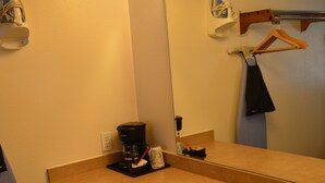 A hotel bathroom with a sink, mirror, towel dispenser, and a coffee maker. - #25- ONE KING BED hotel with WiFi, AC in fabulous Columbia Falls. 20 mi to GNP (Columbia Falls)