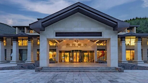 Ein Hotel mit modernem Design, das eine markante Eingangstür mit Glas und eine Beschilderung darüber zeigt.