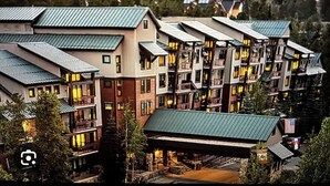 Un hotel a più piani con una serie di balconi e un’area esterna coperta.