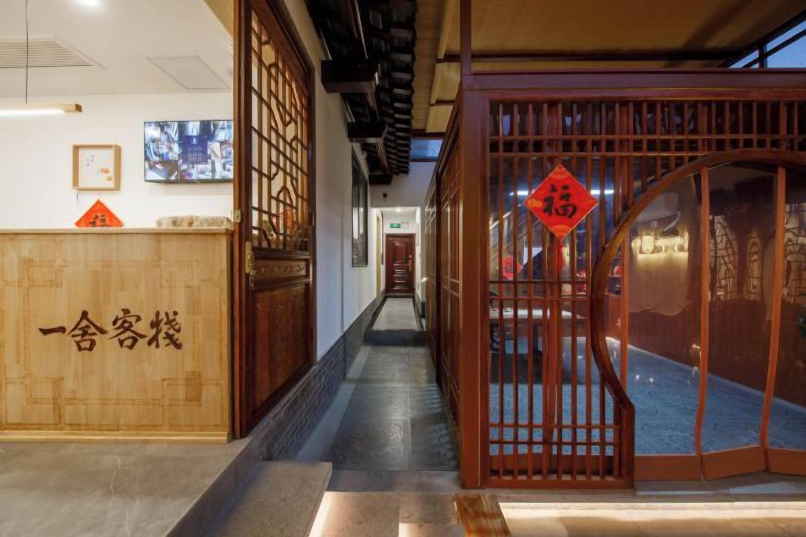 A traditional Japanese-style reception area with a wooden reception desk and a sliding gate.