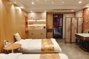 A hotel room with two beds, a small table, a desk, and a traditional partition. - Yishe Inn (Yangzhou Slender West Lake Branch) (Yangzhou)