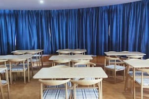 Una habitación con varias mesas y sillas dispuestas en semicírculo.