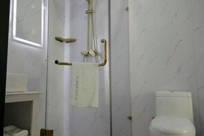 A bathroom with a white toilet, a towel rack with a white towel, and a shower area with a glass door. - 7 Days Premium (Zibo Zichuan Hongtai) (Zibo)