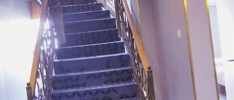 A spiral staircase with a patterned floor and metal railing.
