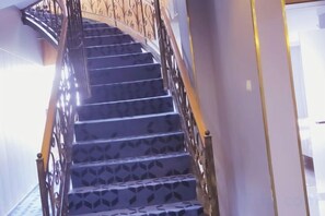 Una escalera de caracol con suelo estampado y barandilla metálica.