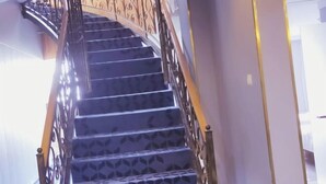A staircase with a patterned carpet and metal railings. - 7 Days Premium (Zibo Zichuan Hongtai) (Zibo)