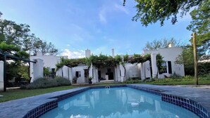 A rectangular swimming pool with a tiled edge, surrounded by a paved deck. - Sundays Karoo Guesthouse (Graaff-Reinet)