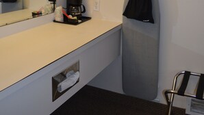 A hotel room with a white vanity, a mirror, a coffee maker, a hanging garment, and a towel rack. - #27- TWO QUEEN BEDS In a Charming hotel in C. Falls with WiFi, AC. 20 mi to GNP (Columbia Falls)