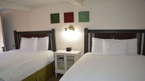 A hotel room with two beds, a nightstand with a lamp, and three wall-mounted artworks. - #27- TWO QUEEN BEDS In a Charming hotel in C. Falls with WiFi, AC. 20 mi to GNP (Columbia Falls)
