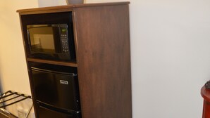A compact kitchenette with a microwave, oven, and refrigerator. A trash can is placed beside the unit. - #27- TWO QUEEN BEDS In a Charming hotel in C. Falls with WiFi, AC. 20 mi to GNP (Columbia Falls)