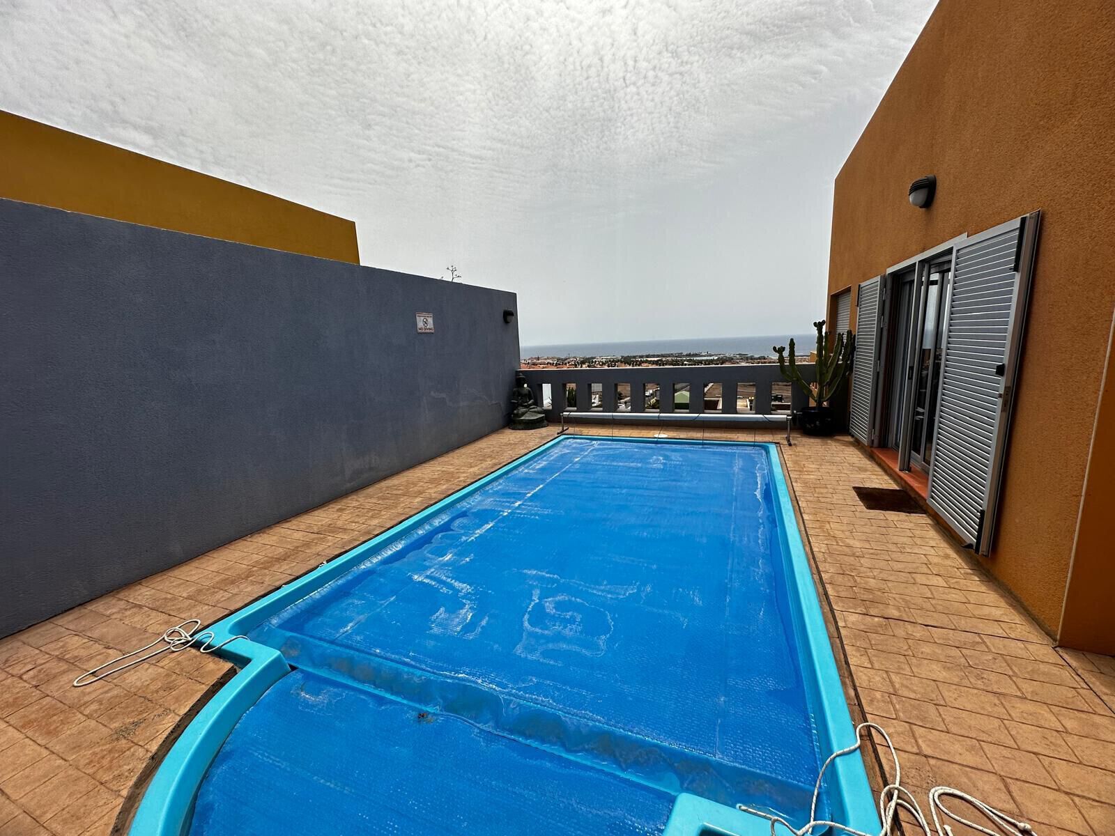 A rooftop swimming pool with a view of the cityscape.