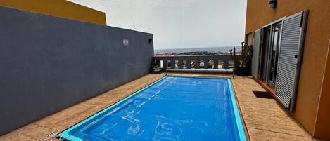 A rooftop swimming pool with a view of the cityscape.