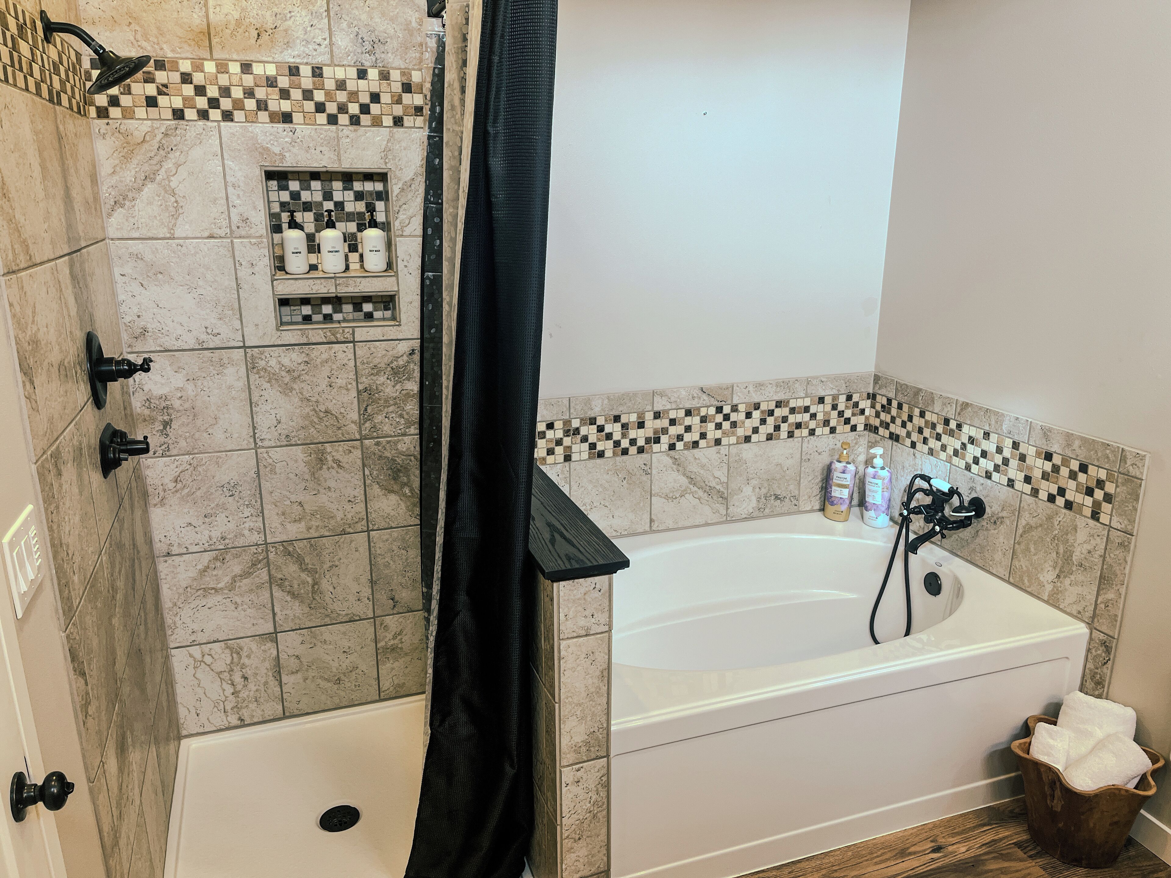 Ein Badezimmer mit Badewanne, Dusche und gefliesten Wänden.