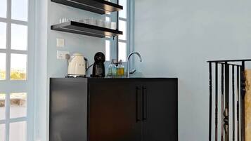 A modern kitchen with black cabinetry, a built-in sink, and shelves above the counter.