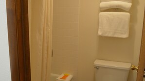 Un baño con bañera, inodoro y barra para toallas.