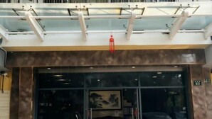 Ein Hotel mit Eingangsbereich, einer Glasüberdachung, einem roten Laternen und einem parkenden Auto.
