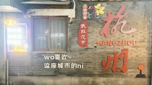 Eine Backsteinmauer mit Schildern für 'HANGZHOU' und 'WUZHOU' in großen Schriftzügen.