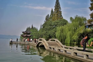 A traditional bridge with a pagoda, surrounded by trees and water. - Hangzhou Shujia Hotel (Hangzhou)