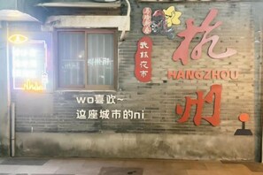 A brick wall with the Hangzhou logo and a neon sign. - Hangzhou Shujia Hotel (Hangzhou)