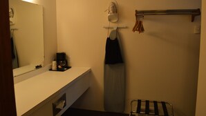 A bathroom with a white sink, a mirror, a towel rack with towels, and a hanging iron. - #29- TWO QUEEN BEDS in Charming hotel in C. Falls with WiFi, AC, 20 mi to GNP (Columbia Falls)