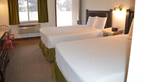 A hotel room with two beds, a desk, a chair, and a window with curtains. - #29- TWO QUEEN BEDS in Charming hotel in C. Falls with WiFi, AC, 20 mi to GNP (Columbia Falls)