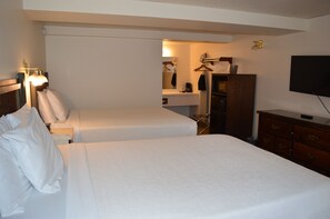A hotel room with two beds, a dresser, a television, and a mirror. - #29- TWO QUEEN BEDS in Charming hotel in C. Falls with WiFi, AC, 20 mi to GNP (Columbia Falls)