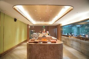 A modern hotel lobby with a central reception desk, a glass partition, and a seating area. - Guomao Hotel (Yueyang)