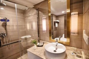 A modern bathroom with a glass-enclosed shower, a round sink, and a large mirror. - Guomao Hotel (Yueyang)
