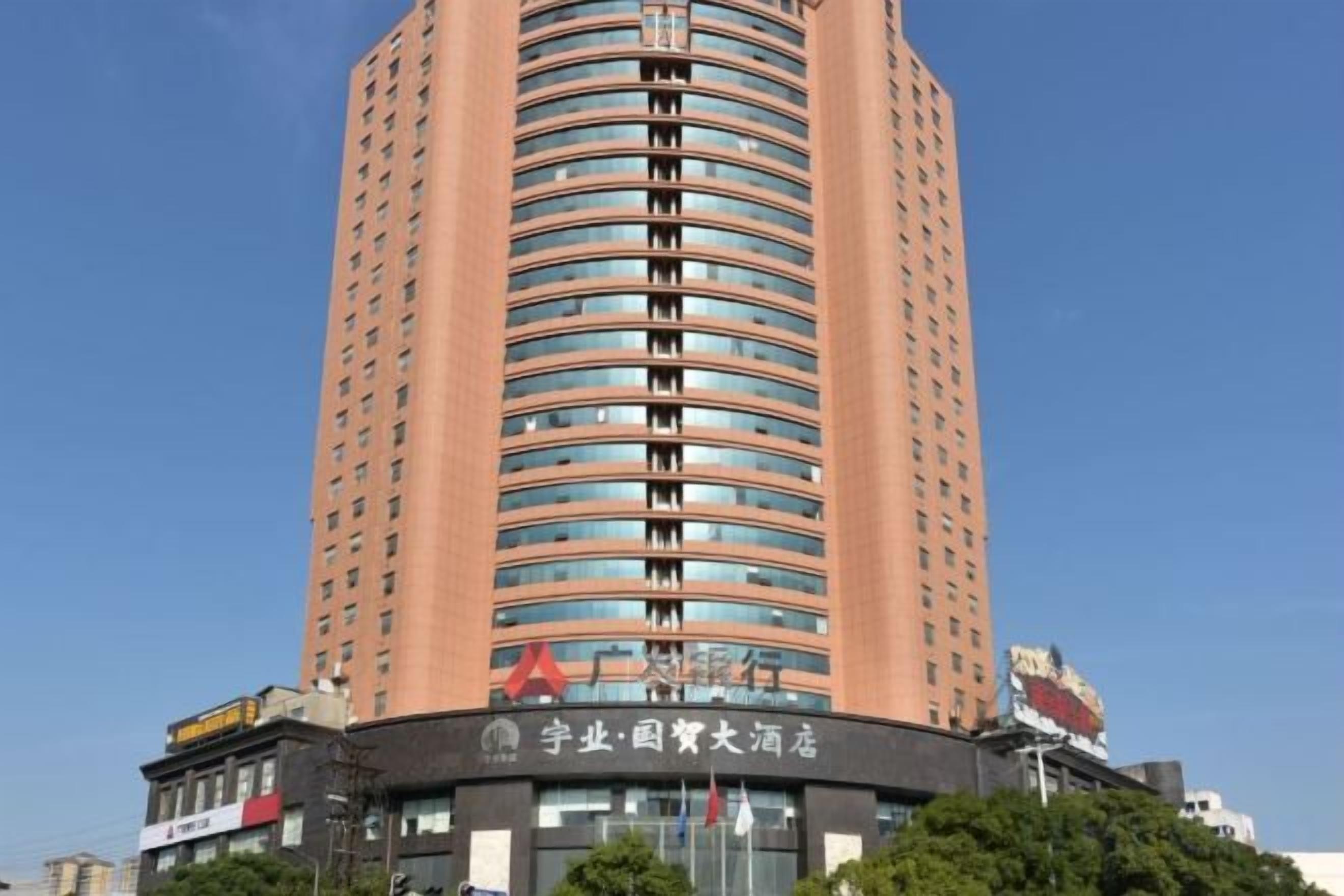 Un edificio hotelero alto y cilíndrico, con fachada curva y varios balcones.
