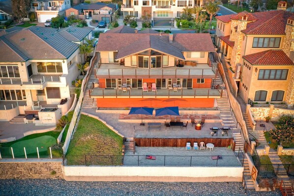 A multi-story residential building with a rooftop patio area featuring outdoor seating and umbrellas.