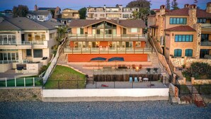 Un edificio residencial de varios pisos con un balcón destacado, una piscina pequeña y un césped bien cuidado.