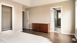 Une chambre à coucher avec un lit, une commode en bois et un dressing.