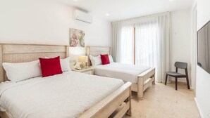 A hotel room with two beds, a desk, a chair, and a TV. - Private 3BR Villa with Pool, BBQ & Spacious Garden (Punta Cana)