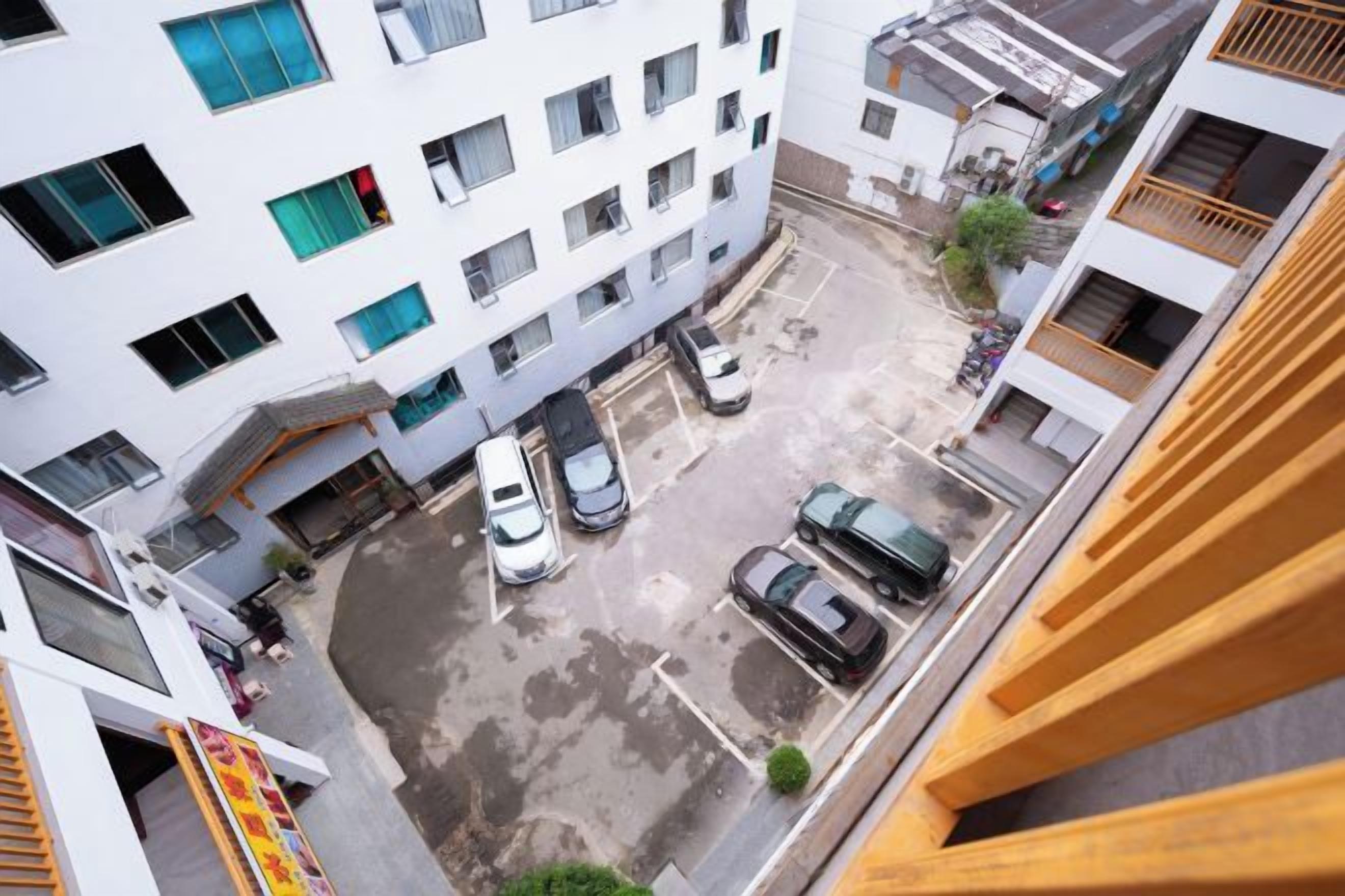 Een meerhoog gebouw met een parkeerplaats ervoor.