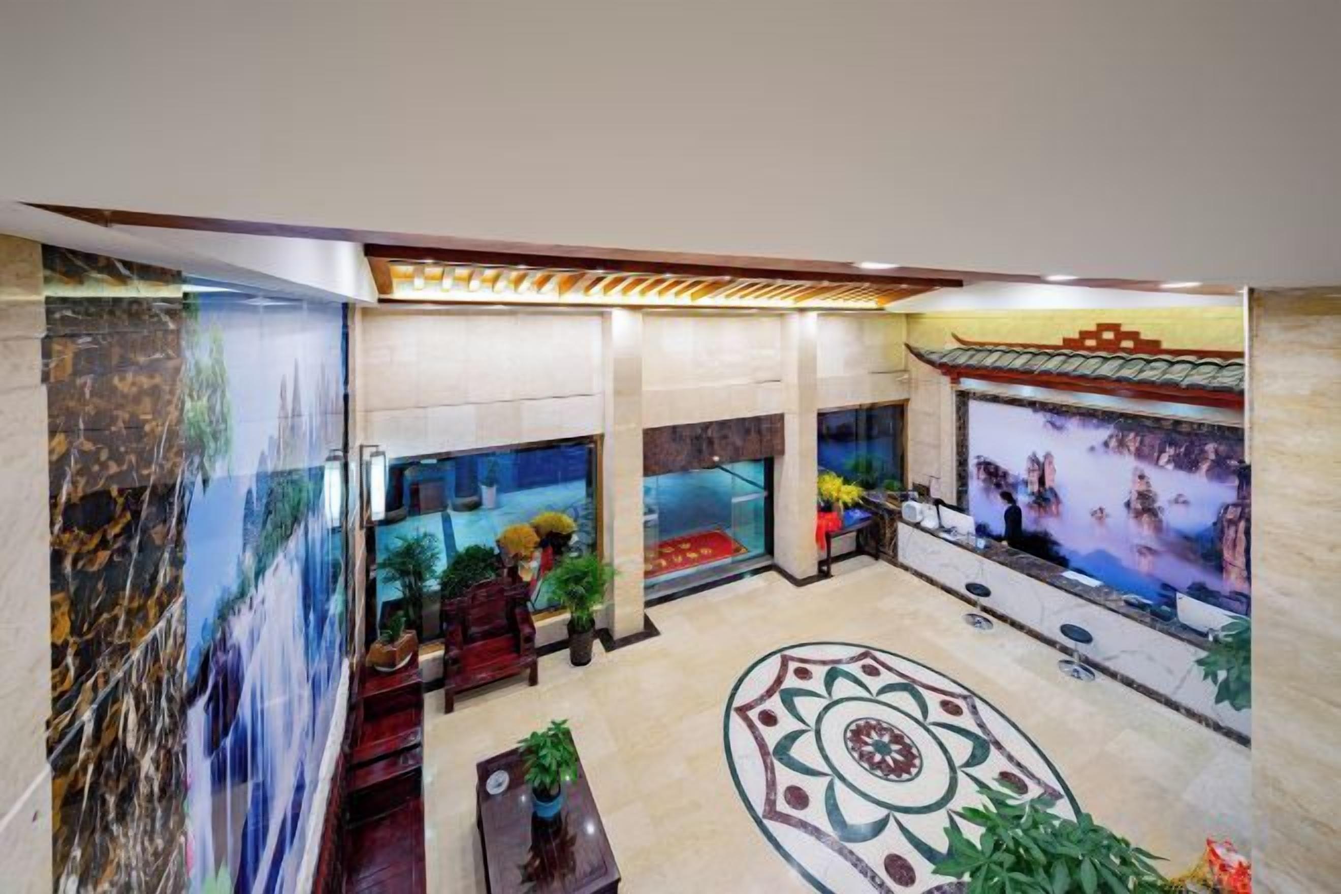 A lobby with a large aquarium, seating areas, and a decorative floor pattern.