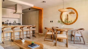 Eine moderne Küche mit Holzausstattung und einem eingebauten Herd. Es gibt einen Essbereich mit einem runden Holztisch und passenden Stühlen.