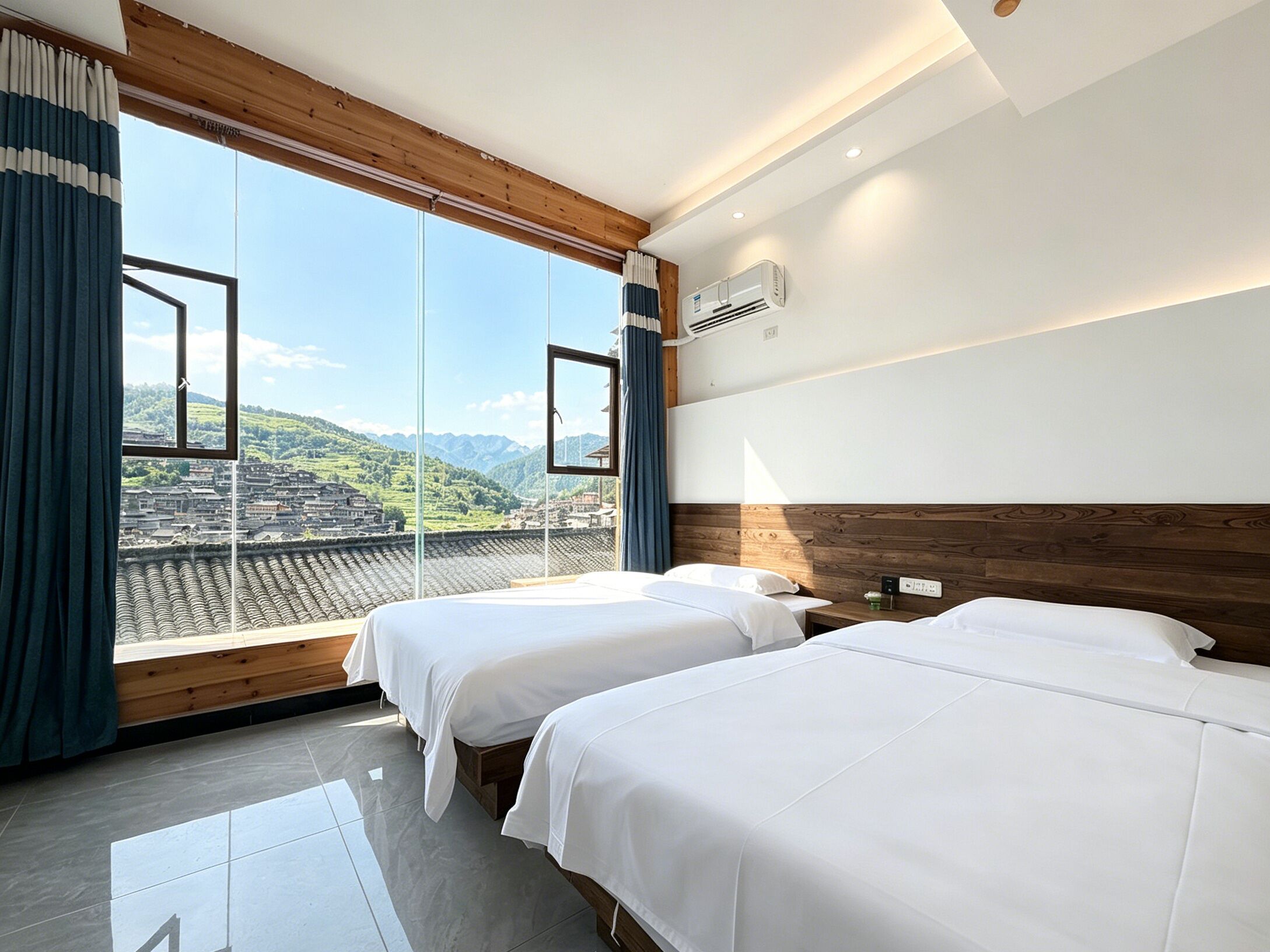 A hotel room with two beds, a large window with curtains, a view of a cityscape, and a wooden headboard.