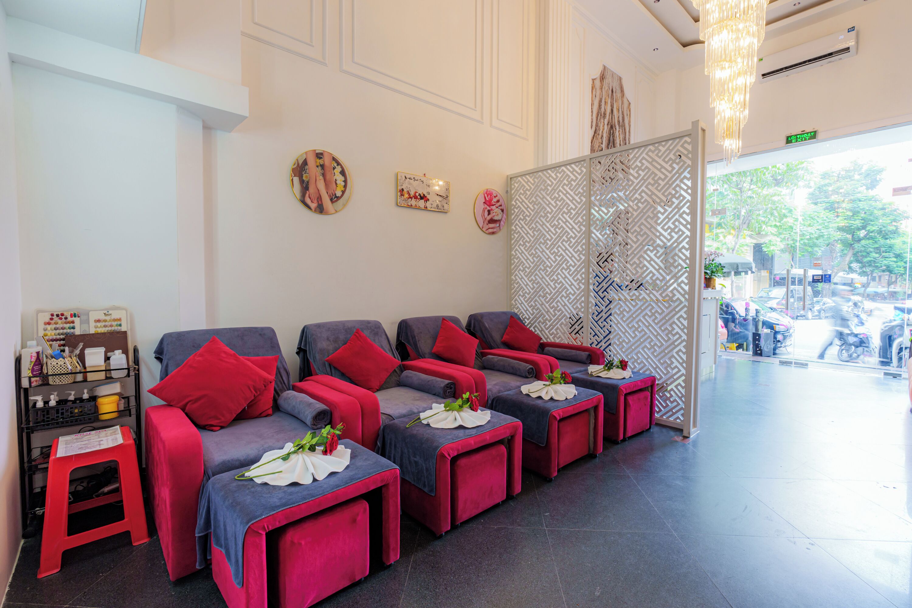 Ein Wellnessbereich mit mehreren Massagesesseln, einem kleinen Hocker und einer Wand mit Kunstwerken.