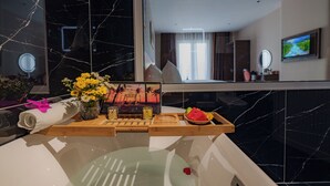 A modern bathroom with a marble sink, a wooden tray with toiletries, and a large mirror. - Salute Saigon Hotel and Spa (Ho Chi Minh City)