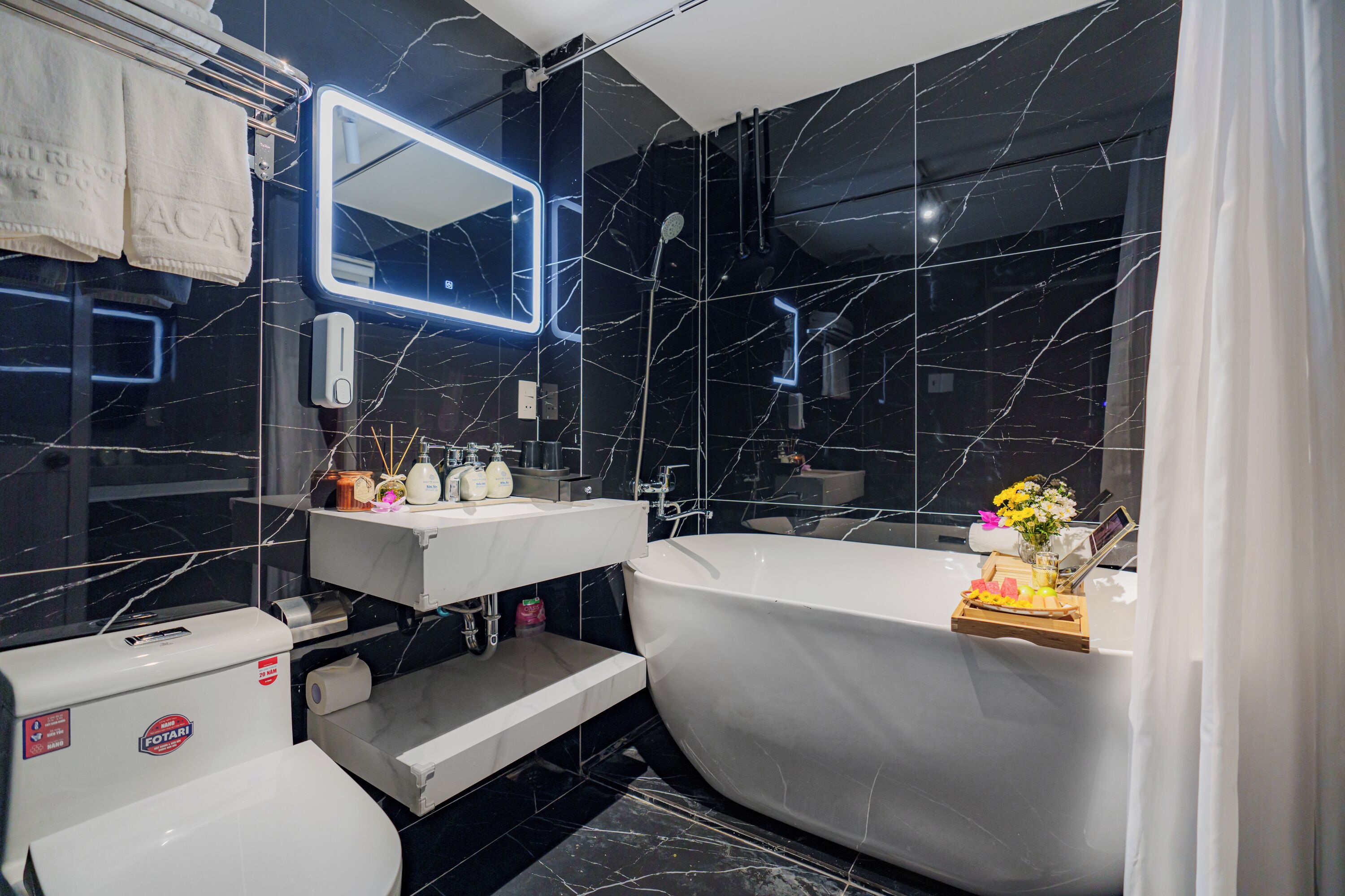 Een moderne badkamer met een groot bad, een wastafel met spiegel en een toilet.