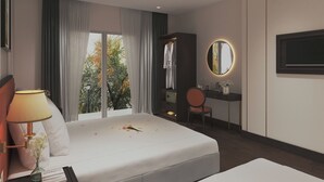 A modern hotel room with a large bed, a desk, a chair, and a TV mounted on the wall. - Salute Saigon Hotel and Spa (Ho Chi Minh City)