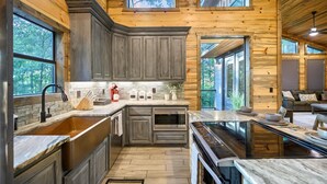 Une cuisine moderne dotée de plans de travail en granit, d’un four encastré et d’un grand îlot central.