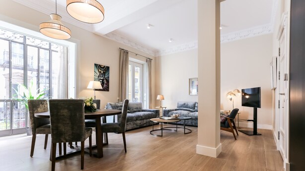 Un salon spacieux comprenant un coin repas, un canapé et un téléviseur.
