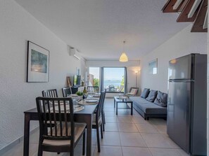 Eine moderne Küche mit Essbereich, einer Couch und Meerblick.