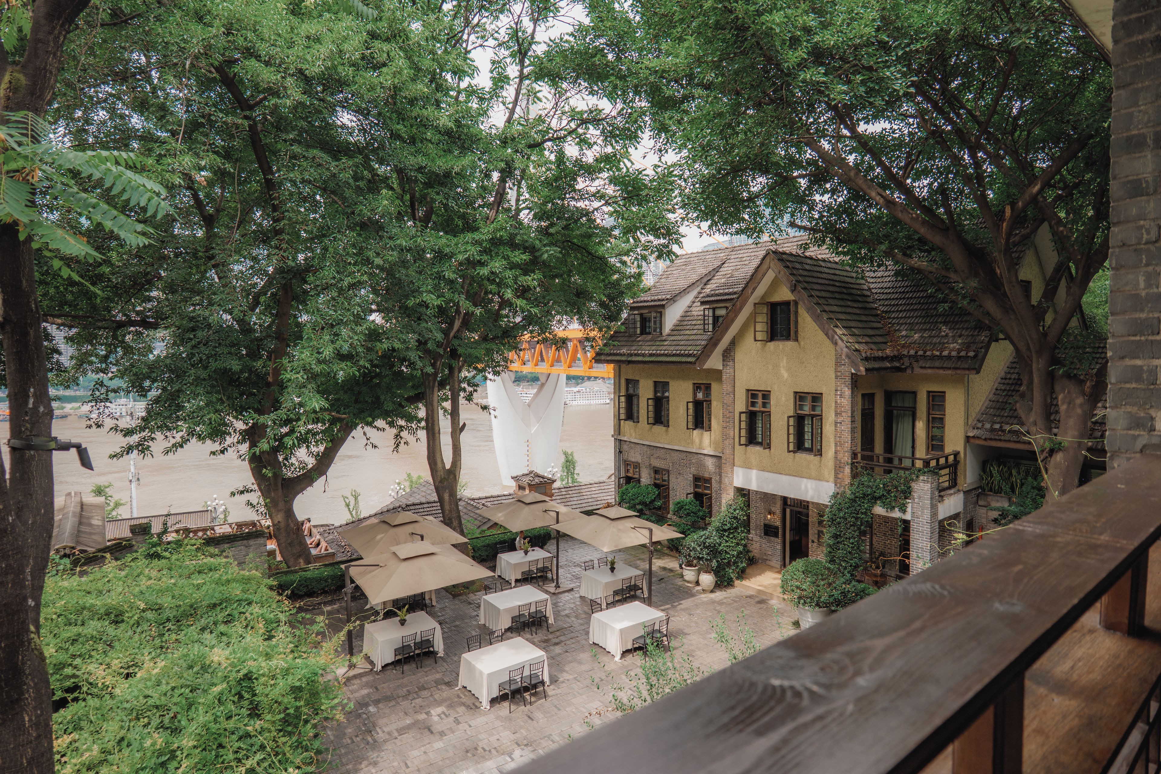 A courtyard with outdoor seating and a building with a sloped roof.