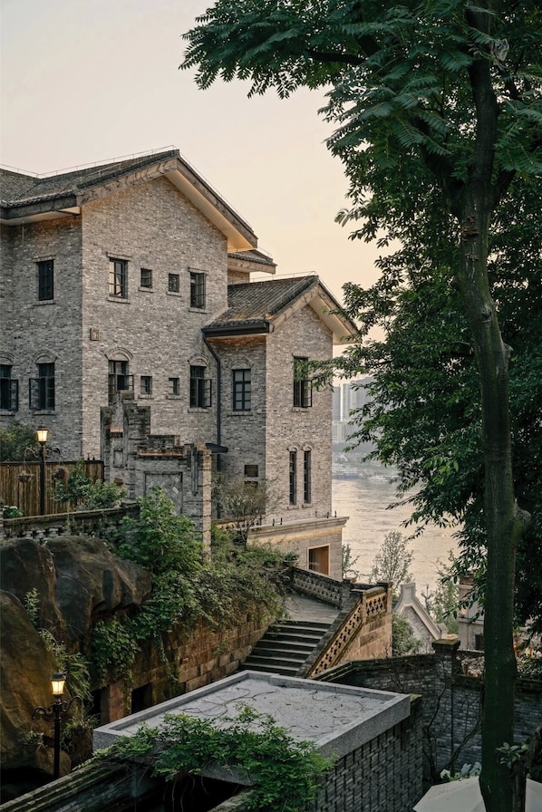 A multi-story stone building with a traditional design, featuring a staircase leading to an upper level.