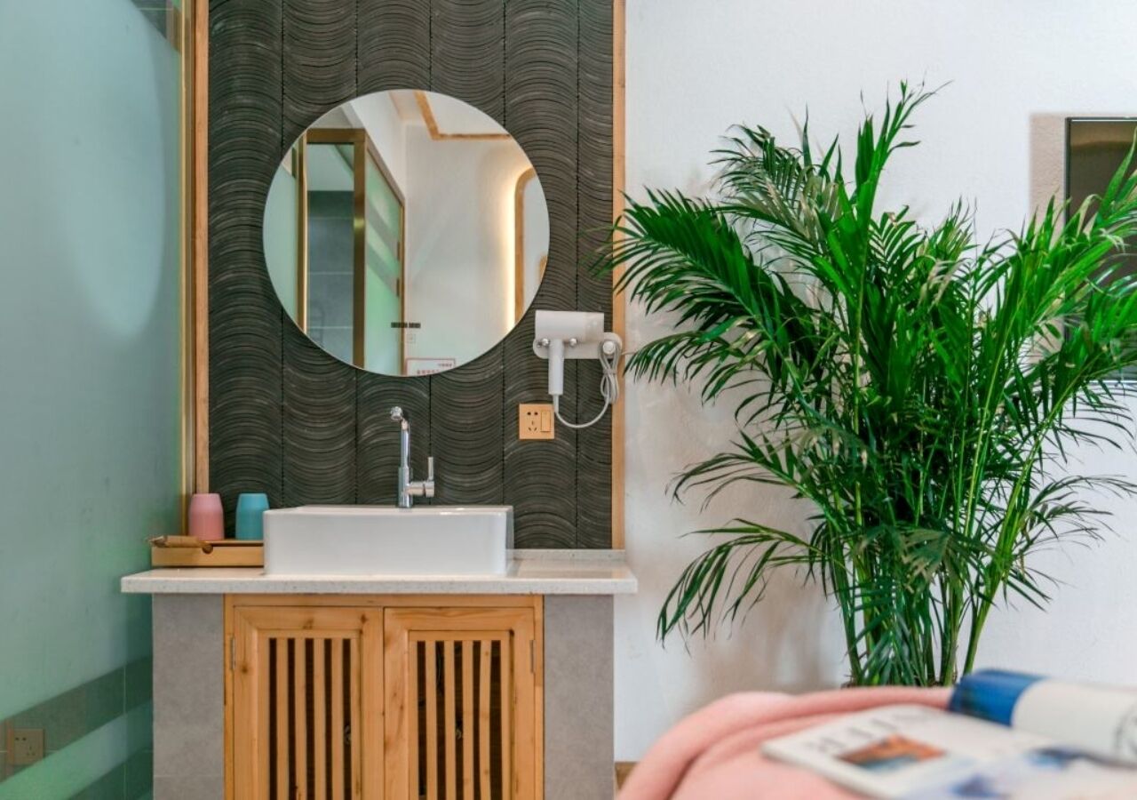 A bathroom with a sink, mirror, and wooden cabinet.